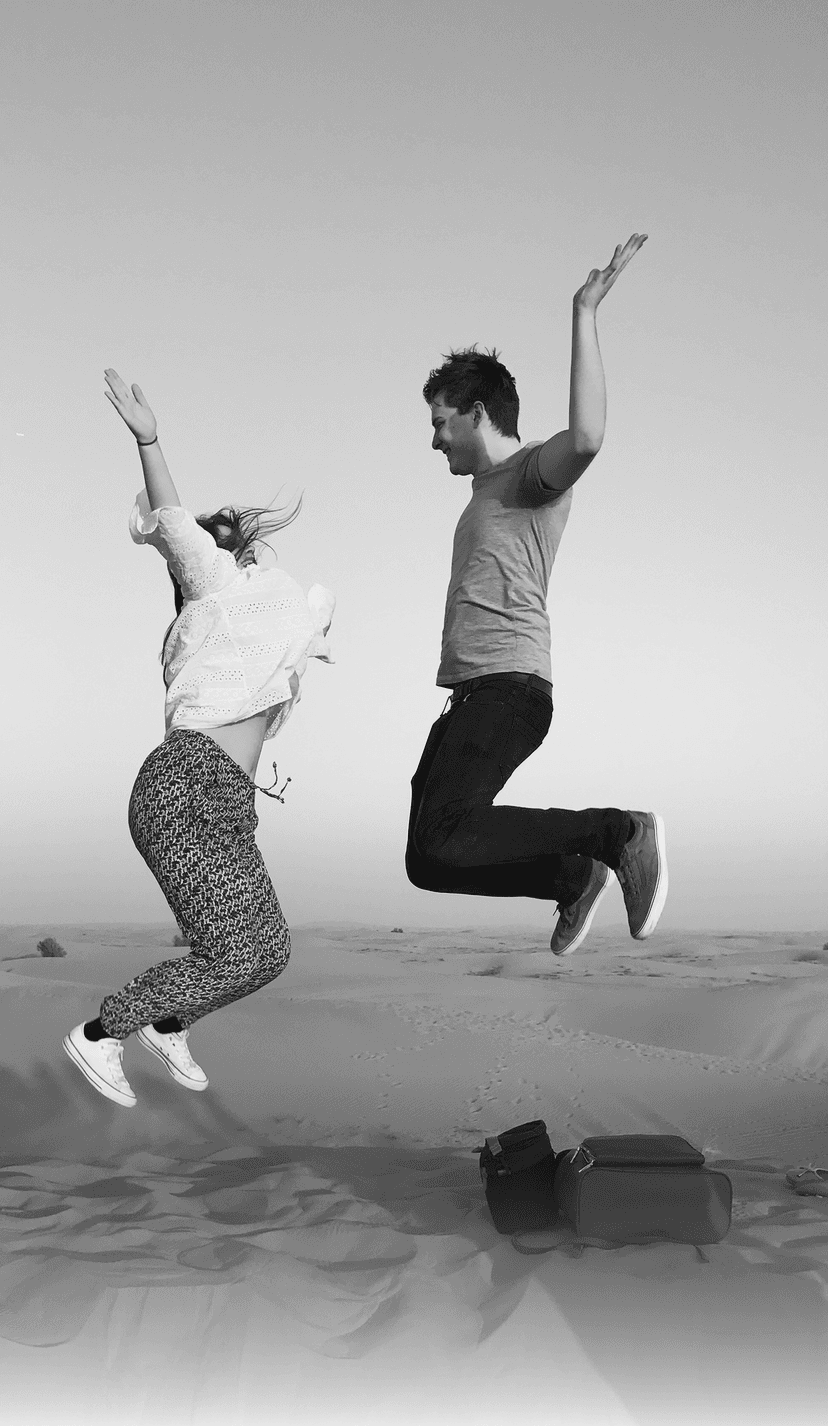 Cristina and Aran jumping up in the air in the dessert in Dubai